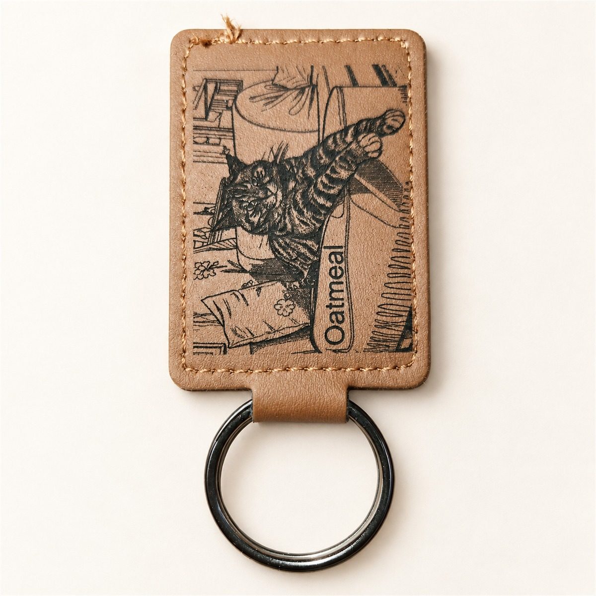 Tan leatherette keyring engraved with a tabby cat and the name Oatmeal.